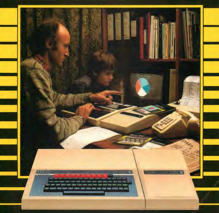 In a home office setting, a man and child sit at a desk using a BBC Micro system connected to peripherals, with a small monitor displaying a pie chart. A pretty hefty sidecar is attached to the righthand side of the BBC Micro, taking up a large portion of the desk.