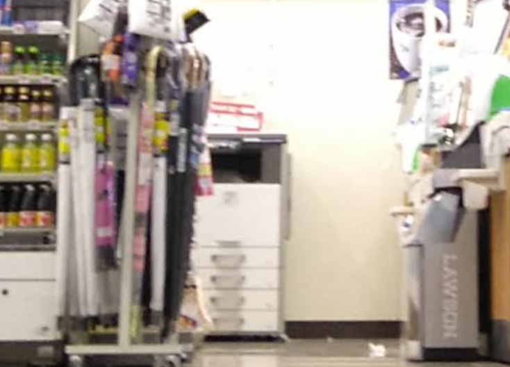 Blurry shot from Google Maps showing the interior of a Japanese convenience store, a copy machine against the far wall.